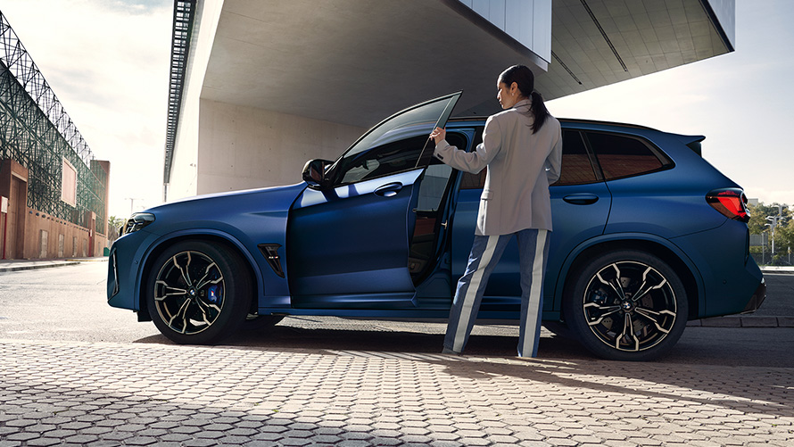 BMW X3 M Competition F97 LCI Facelift 2021 Frozen Marina Bay Blue metallic side view with open door and female model