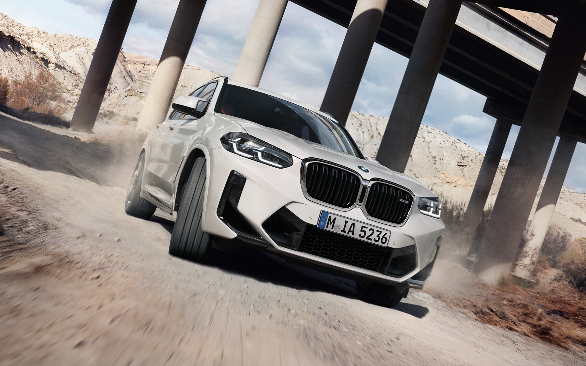 BMW X3 M F97 LCI Facelift 2021 Alpine White three-quarter front view driving around a bend